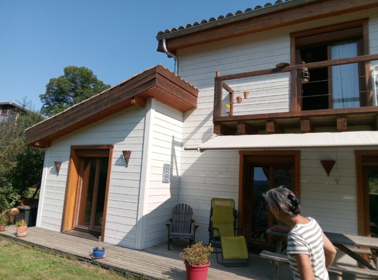 Maison en ossature bois avec peinture blanche sur bardage bois